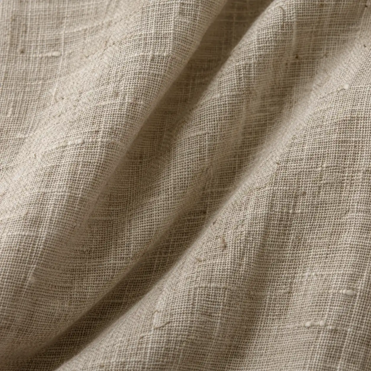 Close detail of oatmeal linen, creased and lit from one side